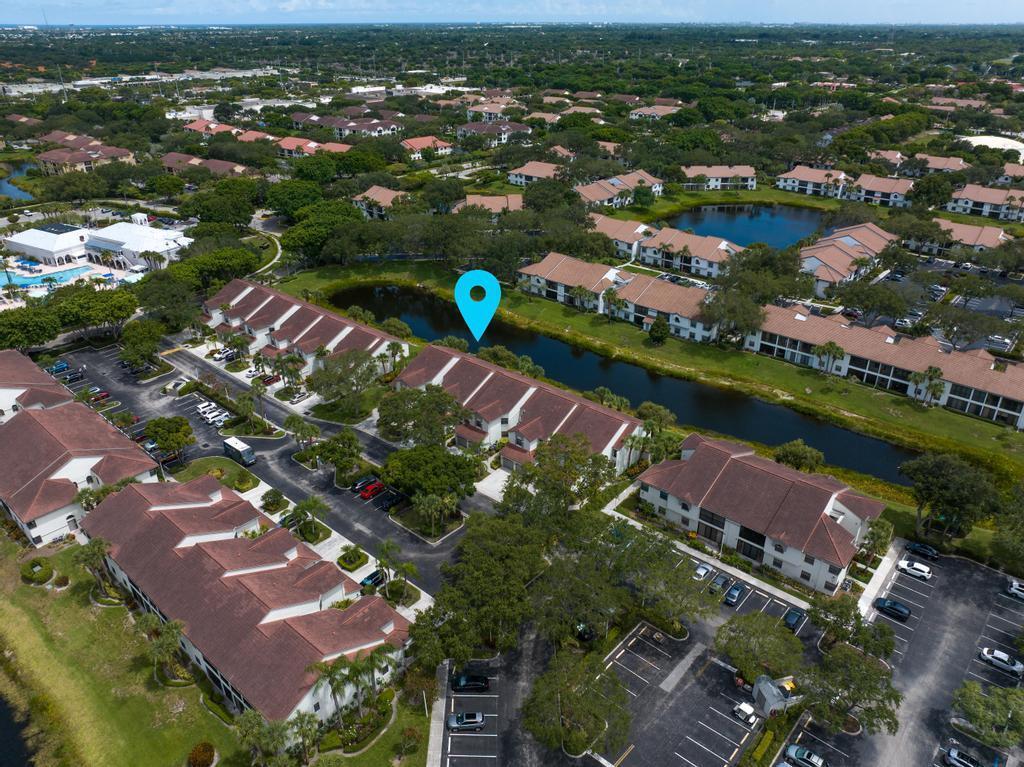 An aerial view shows a residential complex with multi-story buildings, parking lots, and a pond — 5290 Europa Drive # B, Boynton Beach FL 33437, BOYNTON BEACH, FL