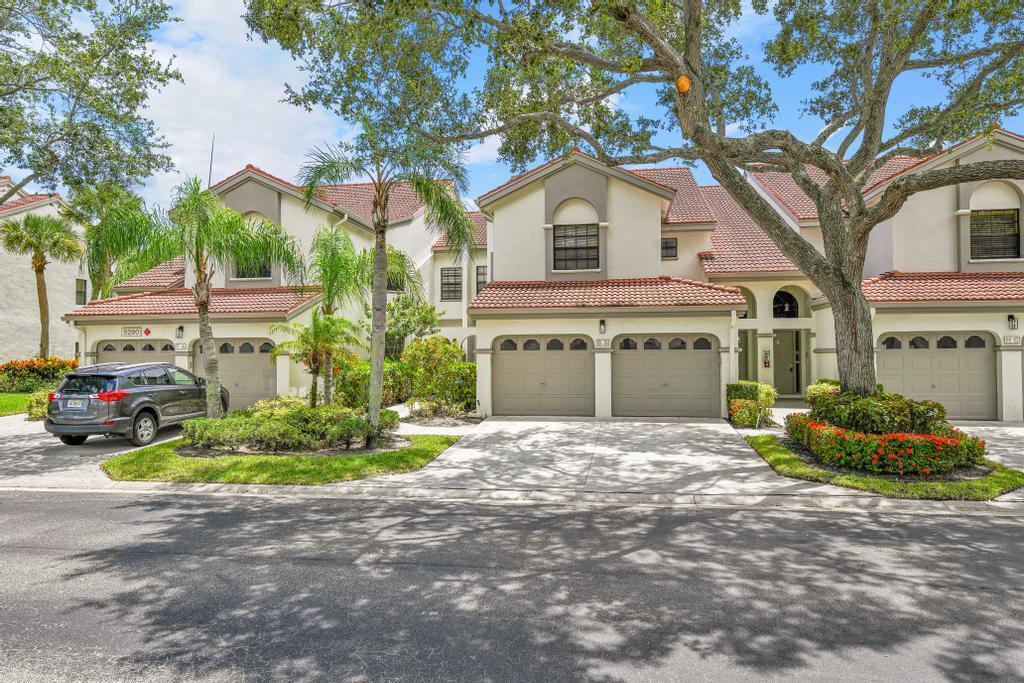 A row of multi-story townhomes with tile roofs, attached garages, and mature trees in front — 5290 Europa Drive # B, Boynton Beach FL 33437, BOYNTON BEACH, FL