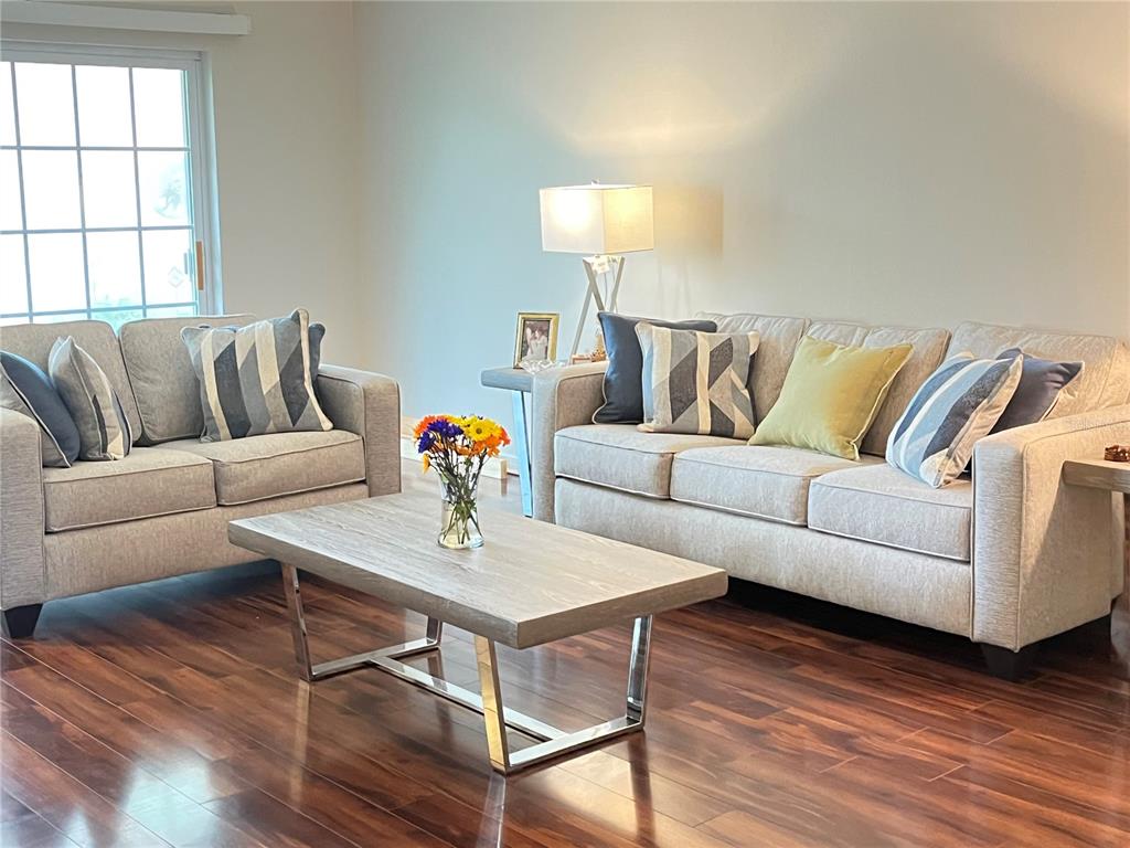 A living room features light gray sofas, a wood-topped coffee table, and dark hardwood floors — 456 WINDMEADOWS STREET UNIT 456, ALTAMONTE SPRINGS, FL