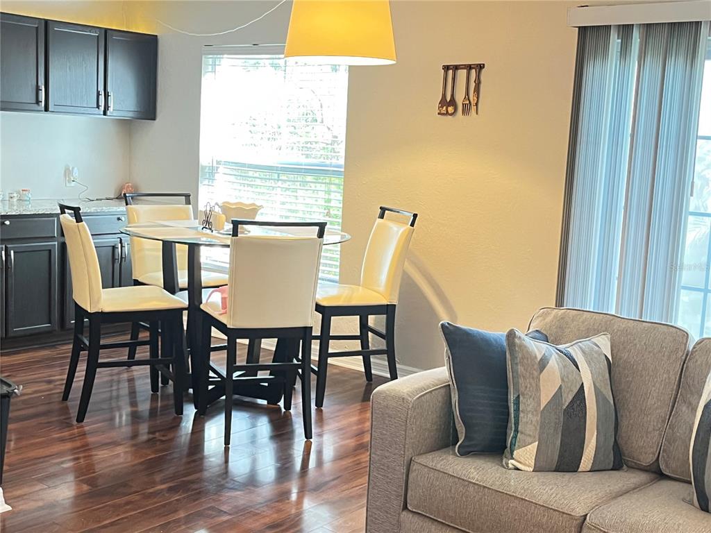 A dining area with a glass table and chairs sits next to a living room sofa — 456 WINDMEADOWS STREET UNIT 456, ALTAMONTE SPRINGS, FL