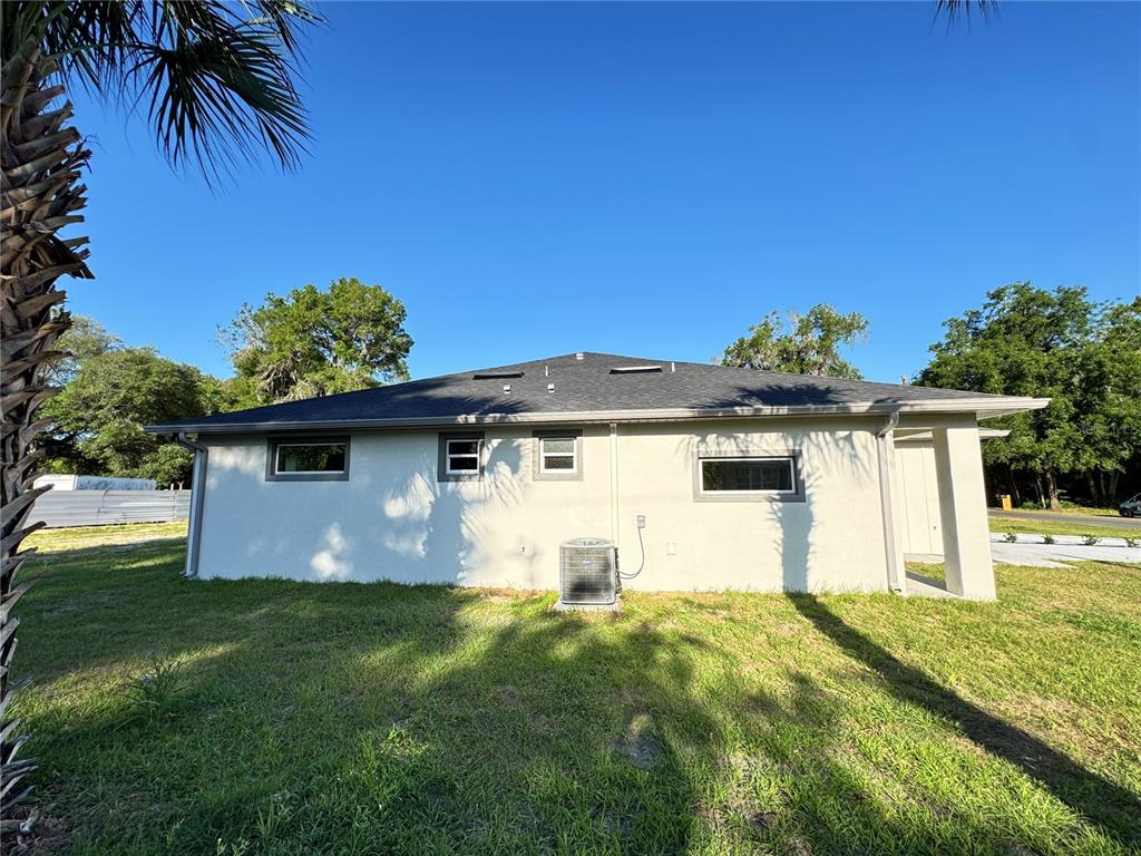 The exterior rear view of a single-story house with a light-colored stucco finish — 1306 NW 8TH STREET UNIT 1 & 2, OCALA, FL