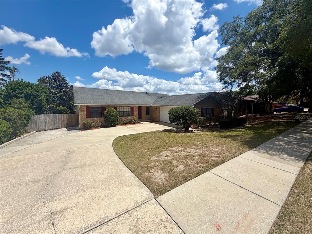 A single-story brick house features a large concrete driveway, a front lawn, and a garage — 37 HOLLOW BRANCH ROAD, APOPKA, FL