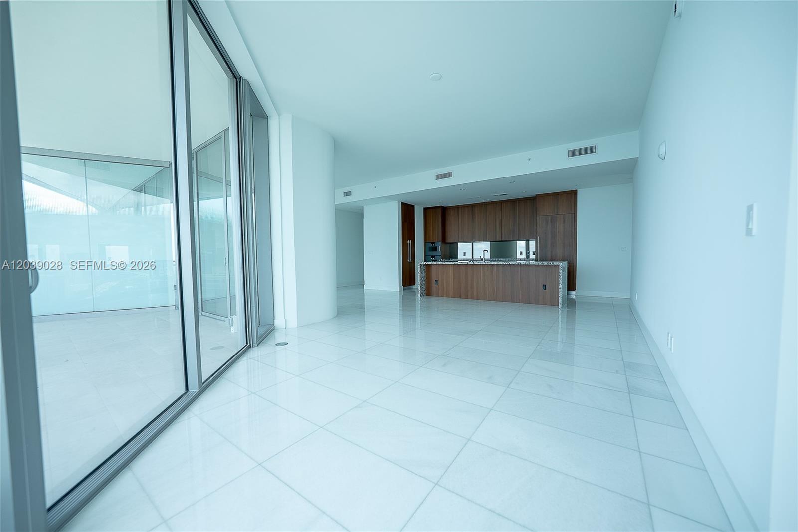 This open-concept living area features white tile flooring, a modern wood kitchen, and floor-to-ceiling windows — 175 SE 25th Rd # 2704, Miami FL 33129, MIAMI, FL