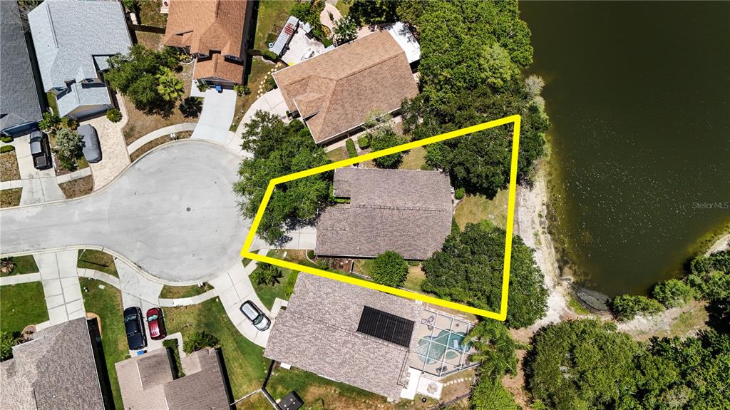 An aerial view shows a house with a yellow outline on a waterfront lot — 7207 SHARPSBURG BOULEVARD, NEW PORT RICHEY, FL
