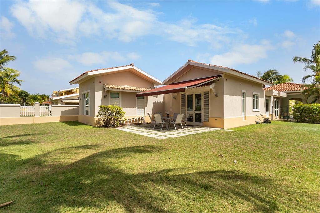 A single-story house with a patio, red awning, and a large grassy backyard — 34 BIRDIE LN, HUMACAO, PR