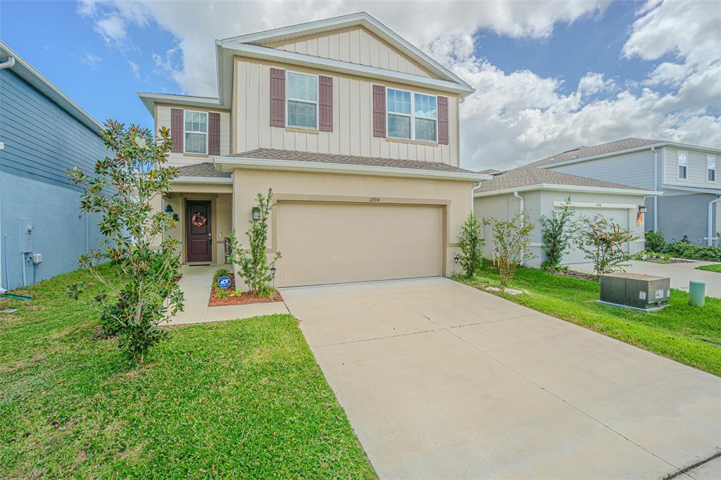 A two-story house with a beige stucco and siding exterior and a two-car garage — 11904 THORNCREST DRIVE, SPRING HILL, FL