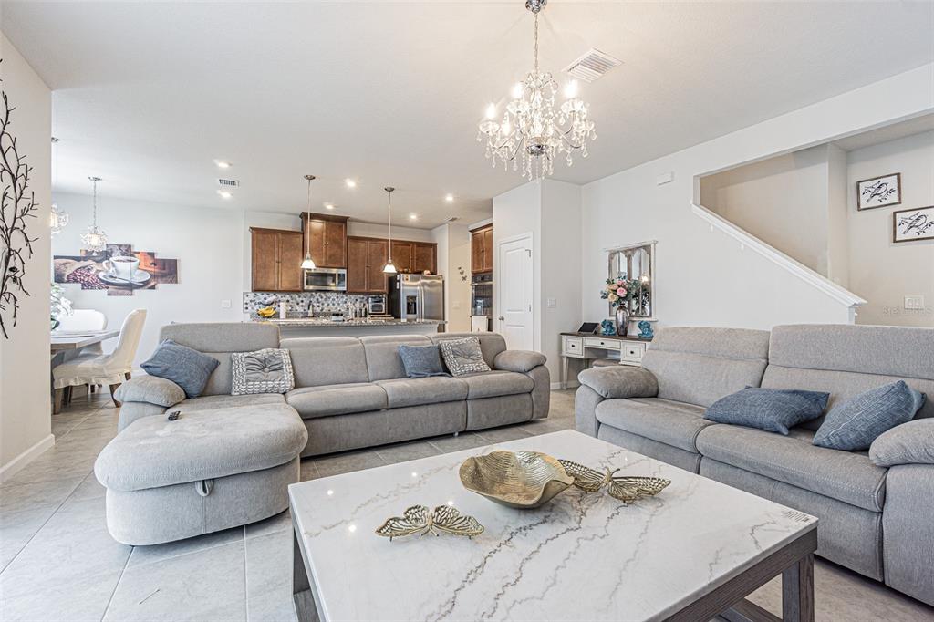A living room with gray sofas, a marble coffee table, and an open kitchen — 11904 THORNCREST DRIVE, SPRING HILL, FL