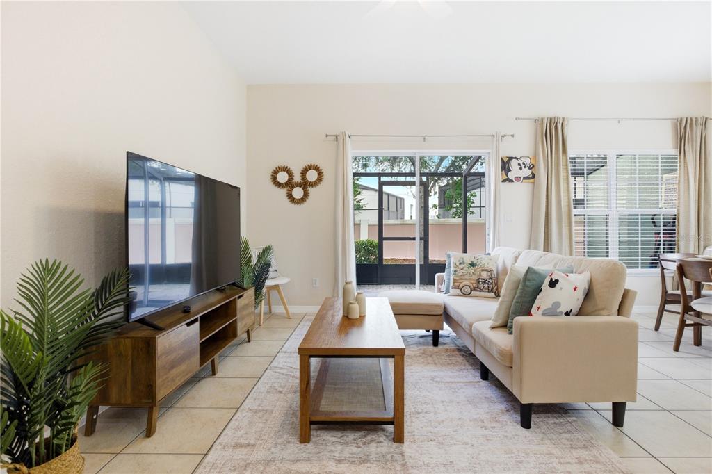 A living room features a beige sectional sofa, a wooden coffee table, and a television console — 2420 CARAVELLE CIRCLE, KISSIMMEE, FL