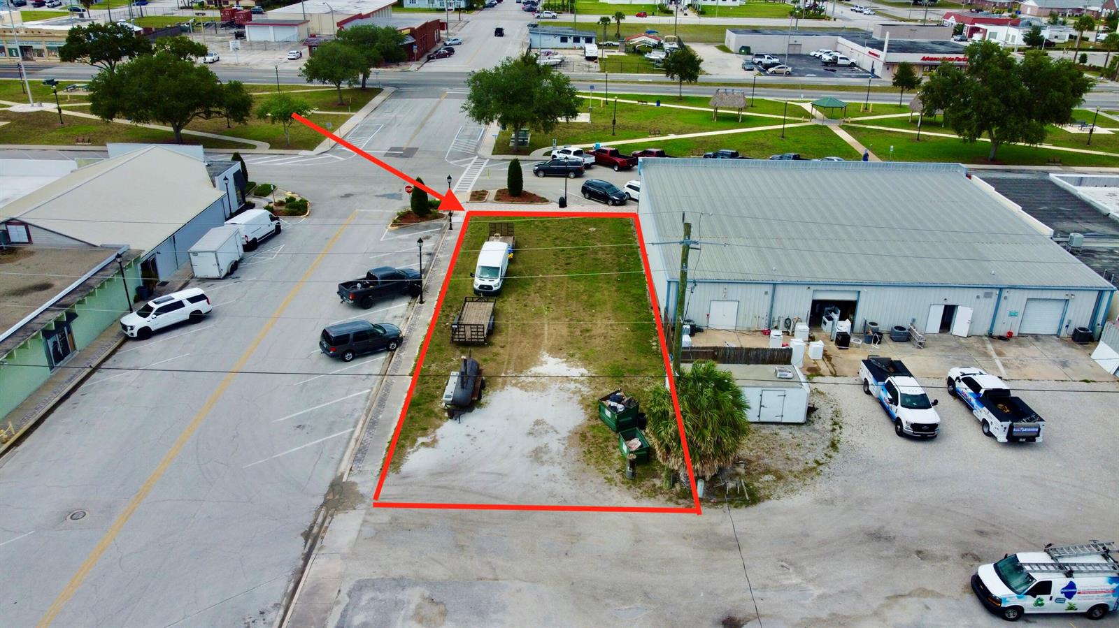 An aerial view shows a vacant rectangular lot outlined in red between two commercial buildings — 320 SW Park Street, Okeechobee FL 34972, OKEECHOBEE, FL