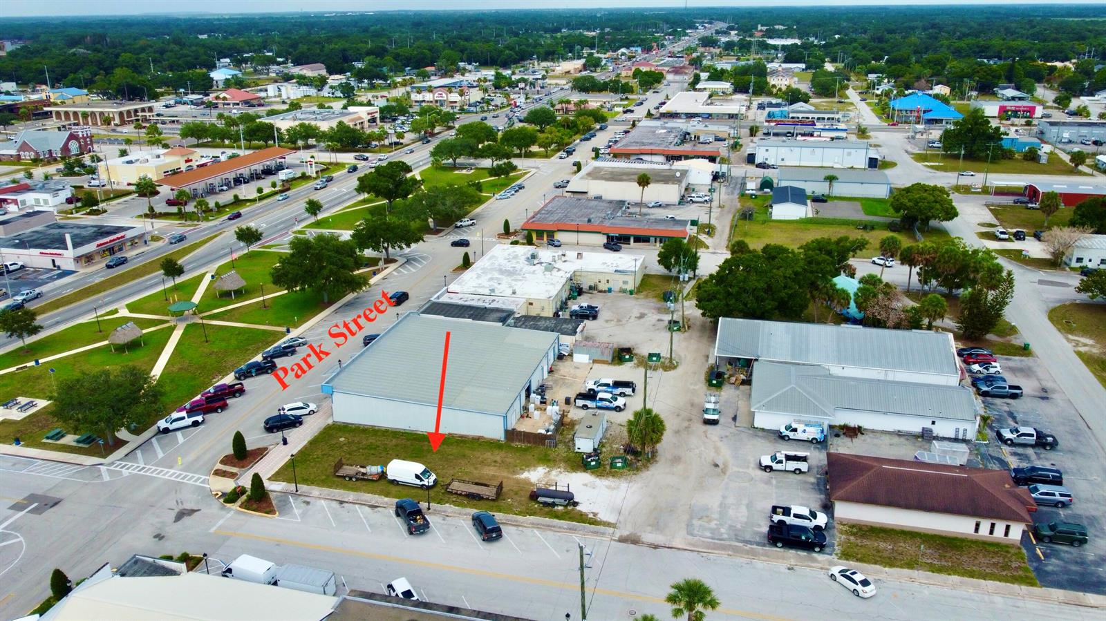 An aerial view shows a commercial building with an adjacent vacant lot and parking area — 320 SW Park Street, Okeechobee FL 34972, OKEECHOBEE, FL