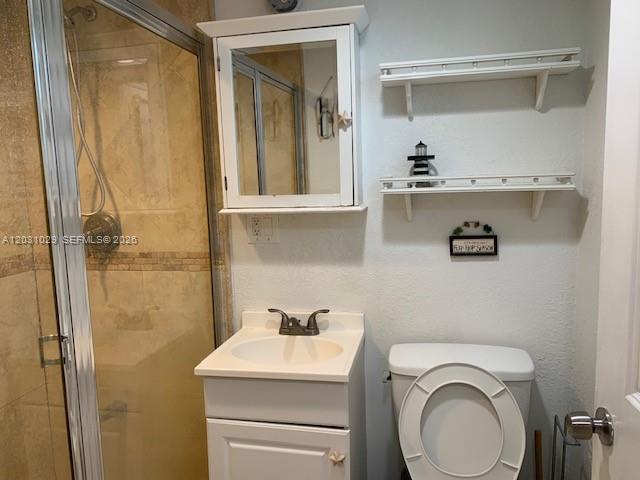 A kitchen features wood cabinets, granite countertops, and a dining area with a glass table — 6490 Collins Ave # 3, Miami Beach FL 33141, MIAMI BEACH, FL