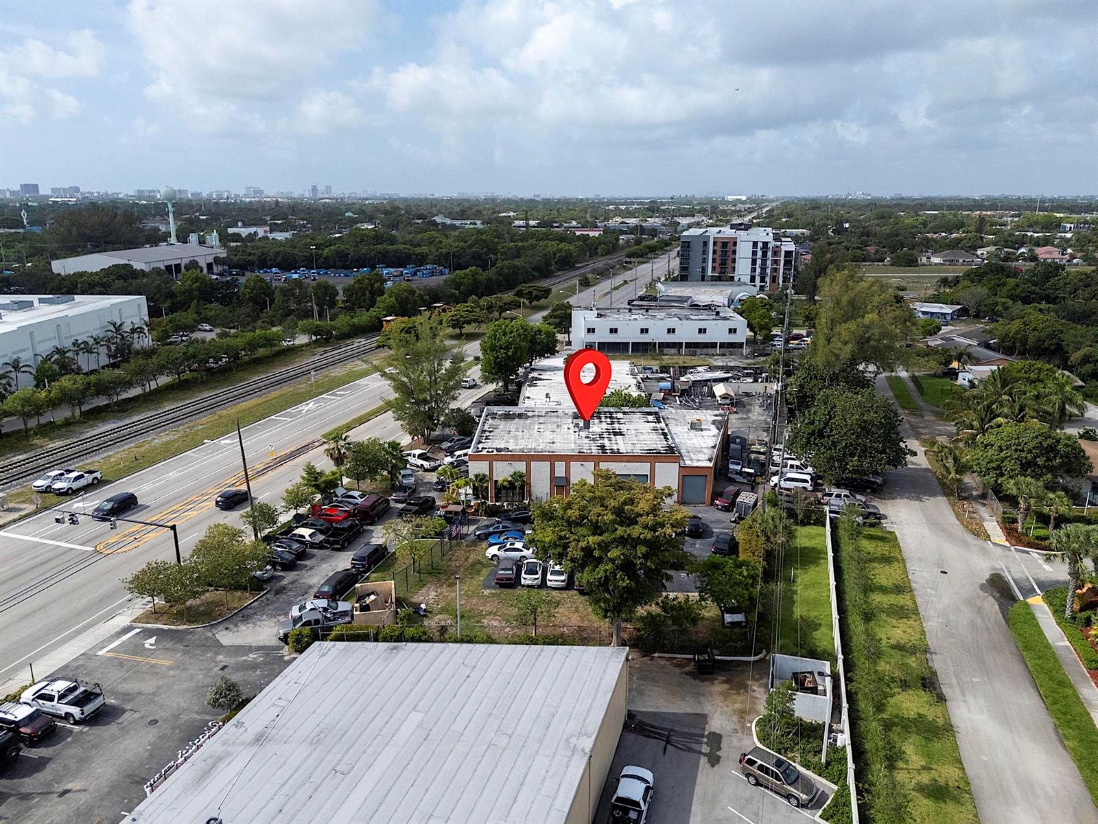 An aerial view shows a commercial building with a red location pin on its roof — 4071 N Dixie Highway, Deerfield Beach FL 33064, DEERFIELD BEACH, FL