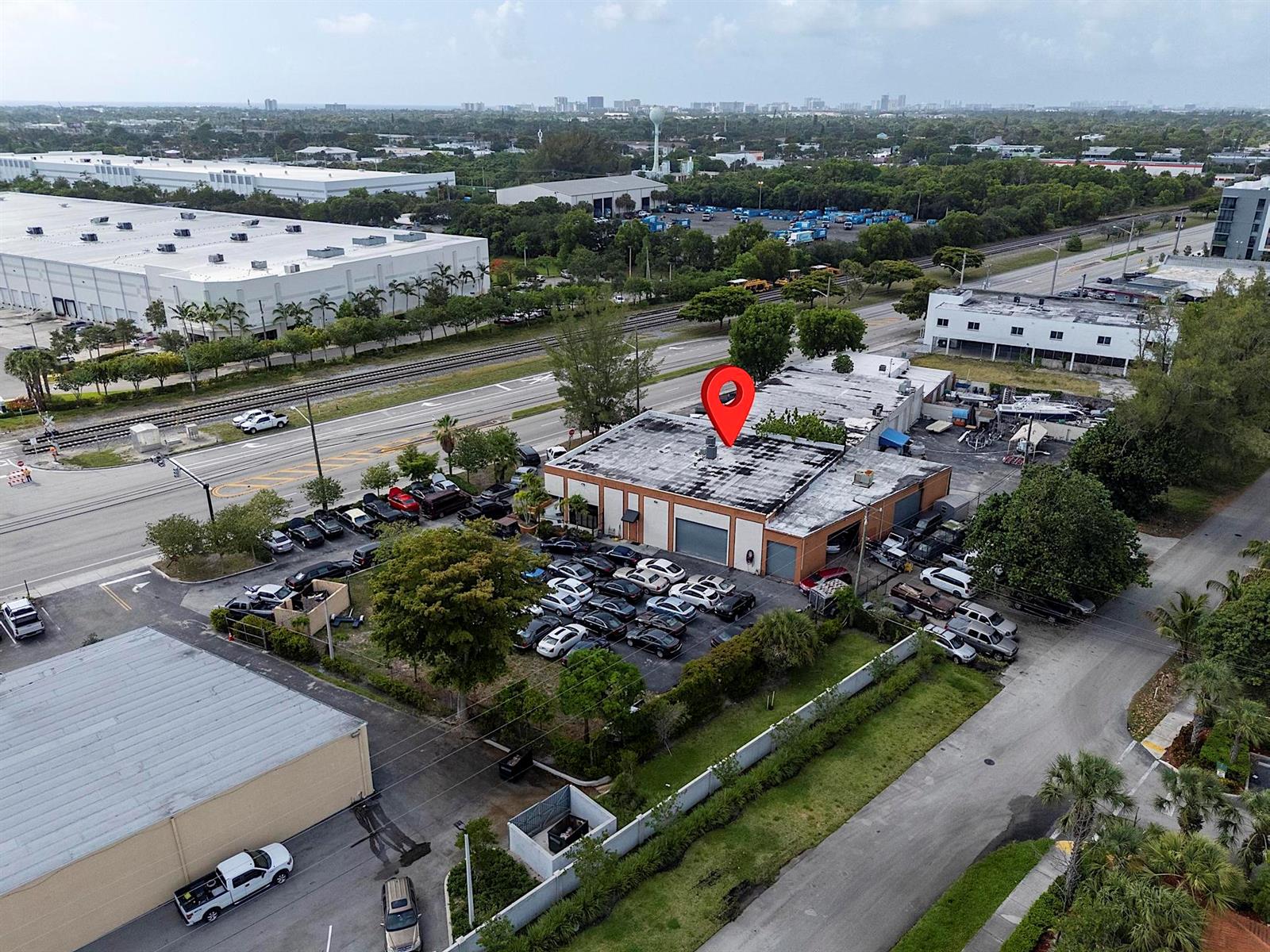 An aerial view shows a commercial building with a parking lot and a red location pin — 4071 N Dixie Highway, Deerfield Beach FL 33064, DEERFIELD BEACH, FL