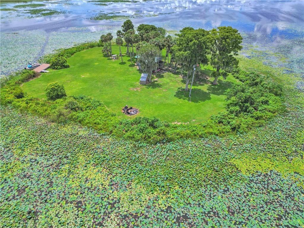 An aerial view of a small, grassy island featuring a house, trees, and a dock — 0 JENNINGS FISH CAMP ROAD, LAKE WALES, FL