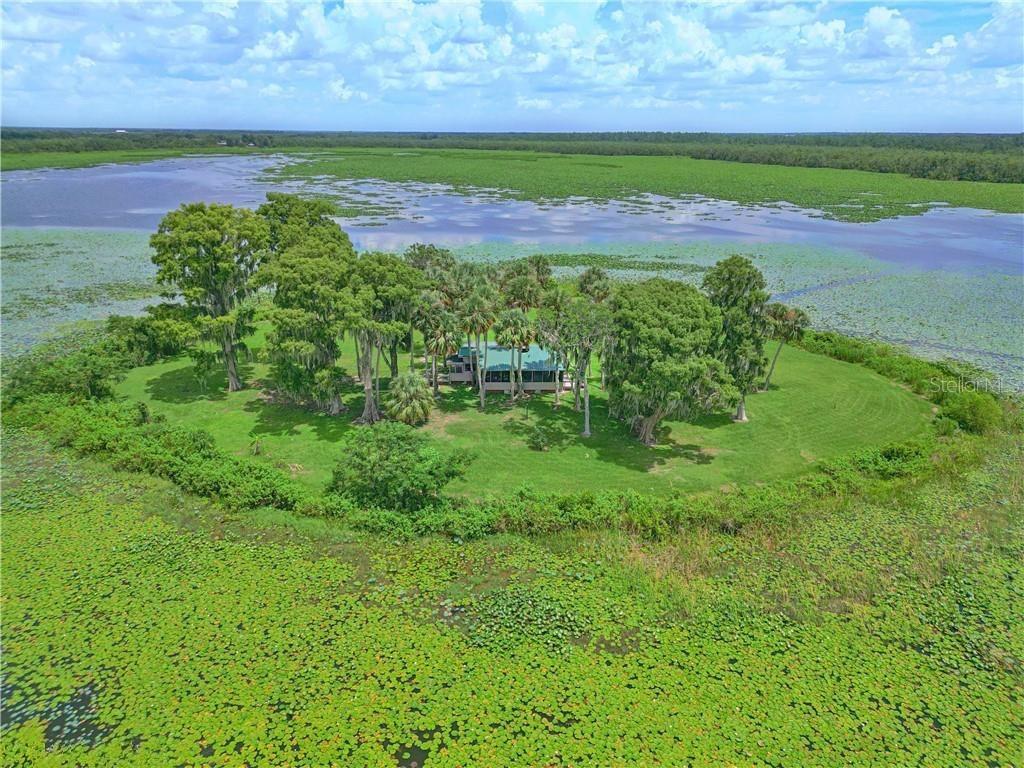 An aerial view shows a house nestled among trees on a small island in a lake — 0 JENNINGS FISH CAMP ROAD, LAKE WALES, FL