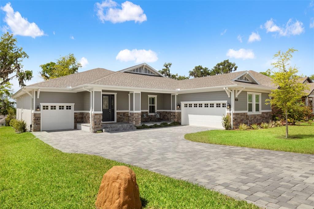 An aerial view of a gray house with a stone facade and a paved driveway — 4829 HICKORY OAK DRIVE, BROOKSVILLE, FL