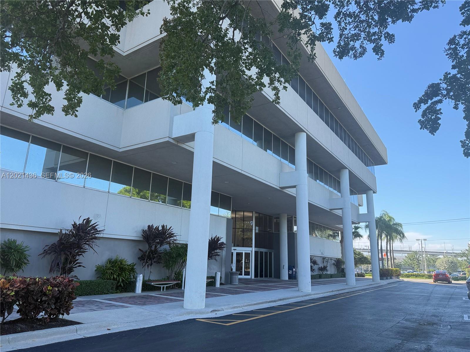 A multi-story office building features a covered entrance with large white columns and landscaping — 290 NW 165th St # 7, Miami FL 33169, MIAMI, FL