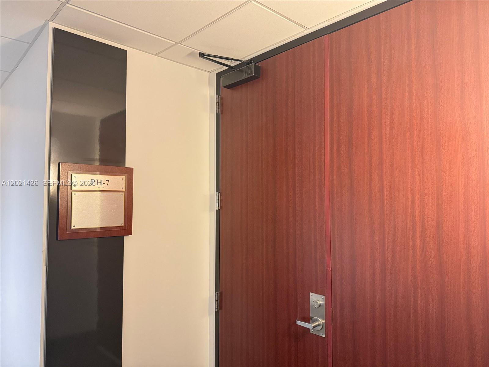 A wooden double door with a metal handle and a wall-mounted plaque — 290 NW 165th St # 7, Miami FL 33169, MIAMI, FL