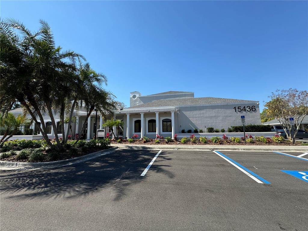 A single-story commercial building with a gray stucco facade and a covered entrance with columns — 15434 N FLORIDA AVENUE, TAMPA, FL