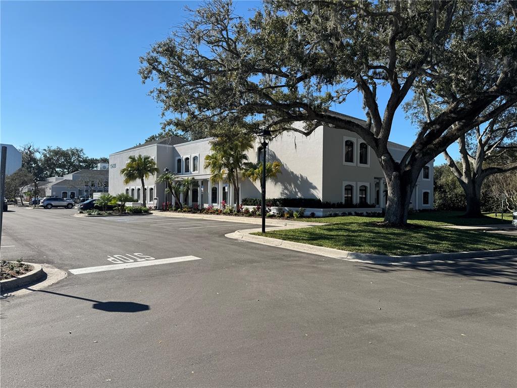A two-story commercial building features a parking lot with a stop sign painted on asphalt — 15434 N FLORIDA AVENUE, TAMPA, FL