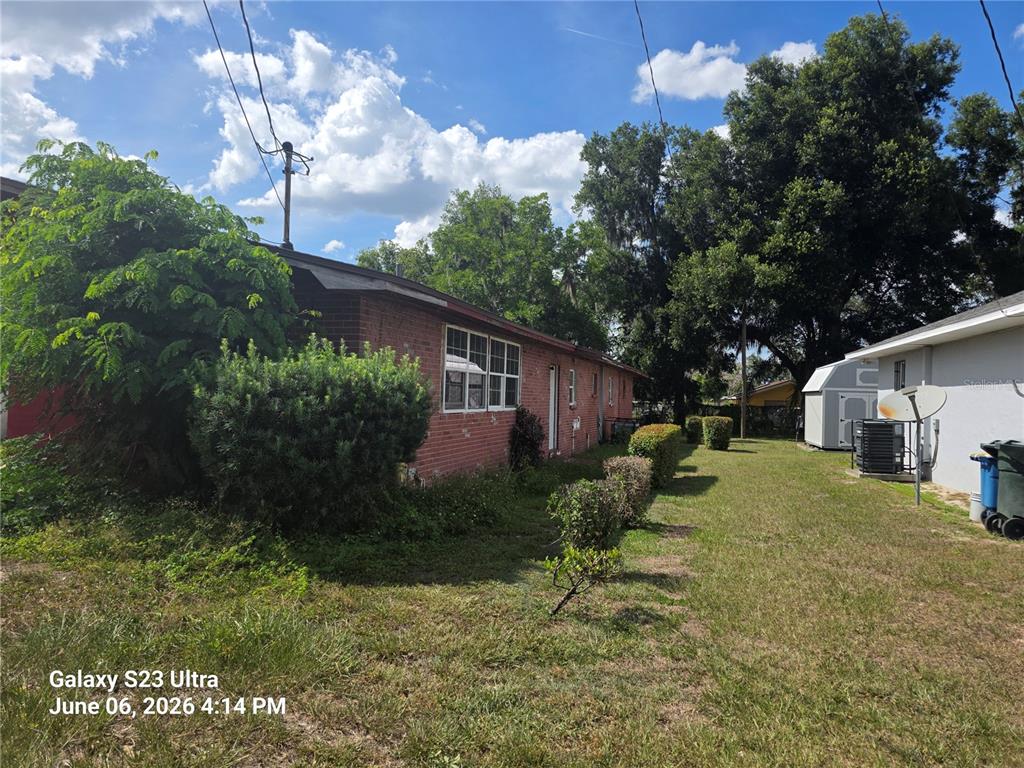 The exterior of a brick house features a grassy yard with shrubs and trees — 2086 MARTIN LUTHER KING JR BOULEVARD, BARTOW, FL