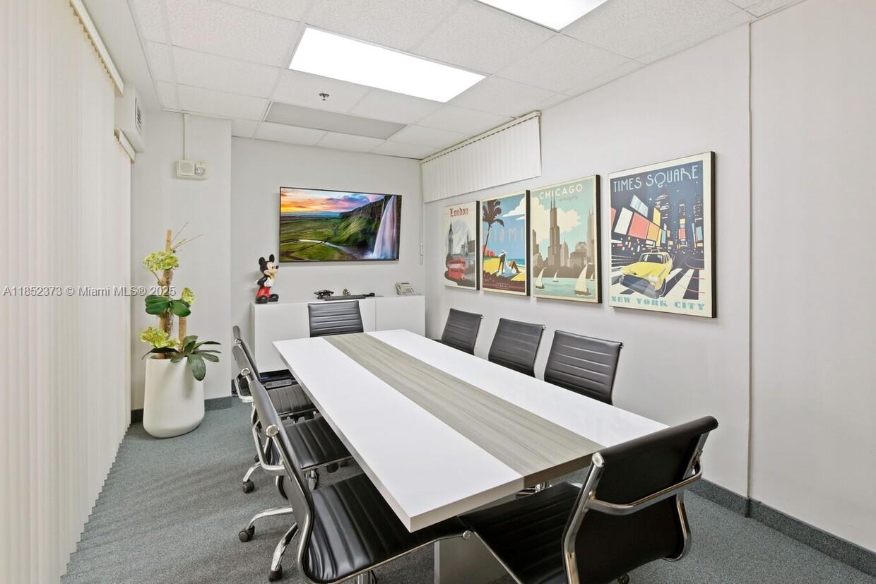 A conference room features a long table, black chairs, wall art, and a wall-mounted television — 168 SE 1st St # 9, Miami FL 33131, MIAMI, FL