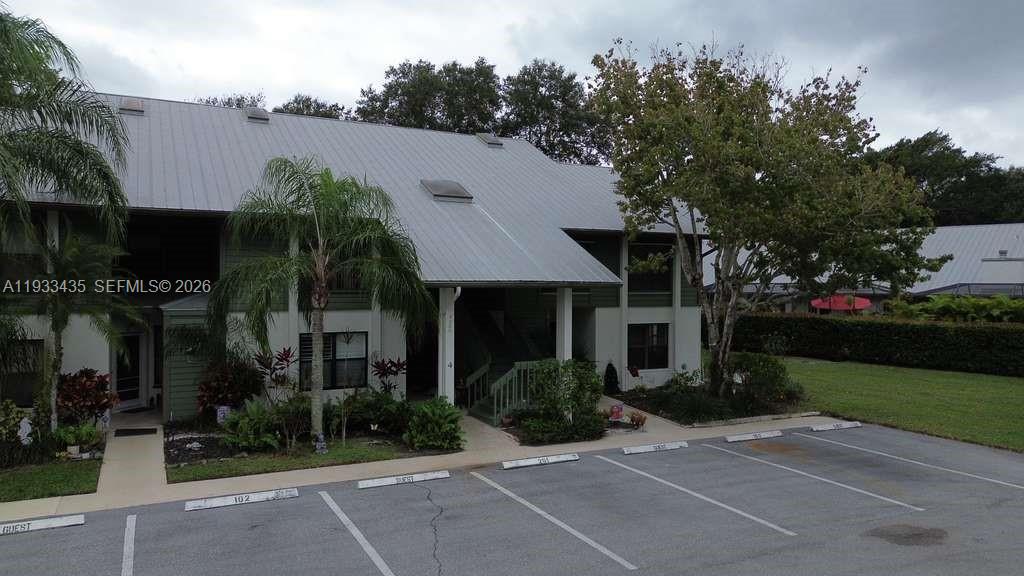 An exterior view of a two-story apartment building with a metal roof and parking — 5200 SE Seascape Way # 201, Stuart FL 34997, STUART, FL