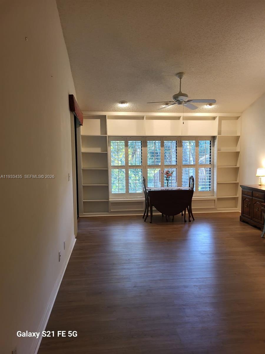 A dining area features built-in white shelving surrounding a large window with plantation shutters — 5200 SE Seascape Way # 201, Stuart FL 34997, STUART, FL