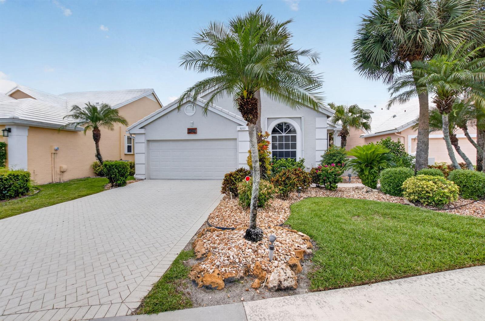 A single-story house with a paved driveway, palm trees, and a landscaped front yard — 8223 Horseshoe Bay Road, Boynton Beach FL 33472, BOYNTON BEACH, FL