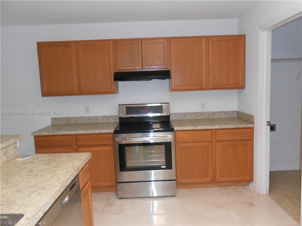 A kitchen features wood cabinets, stainless steel appliances, and beige laminate countertops — 154 Shadowview Ct., Lehigh Acres FL 33974, LEHIGH ACRES, FL