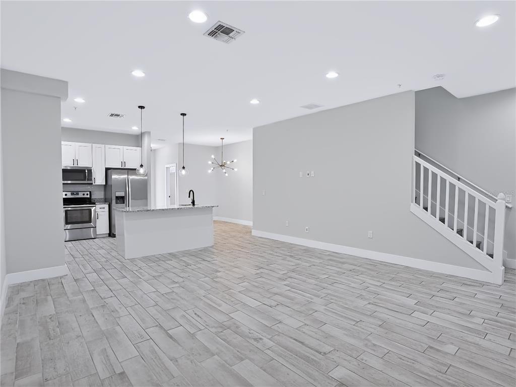 A kitchen features white cabinets, granite countertops, stainless steel appliances, and a central island sink — 2233 E KALEY AVENUE UNIT 6, ORLANDO, FL