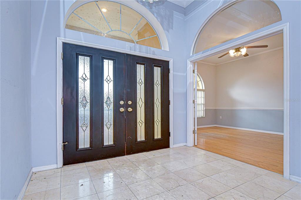 An entryway with tile flooring, double doors with glass inserts, and an arched transom window — 3373 CRESCENT OAKS BOULEVARD, TARPON SPRINGS, FL