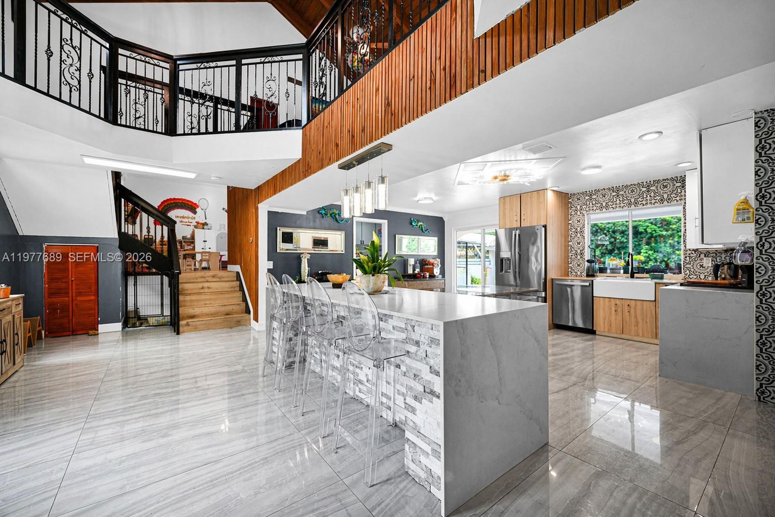 A kitchen features wood-tone and white cabinets, stainless steel appliances, and patterned tile backsplashes — 18950 SW 50th St, Southwest Ranches FL 33332, SOUTHWEST RANCHES, FL