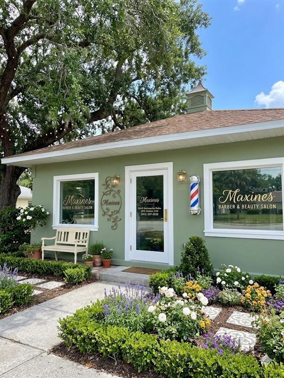 The exterior of a green barber and beauty salon features a white door and windows — 2106 1ST STREET N, WINTER HAVEN, FL