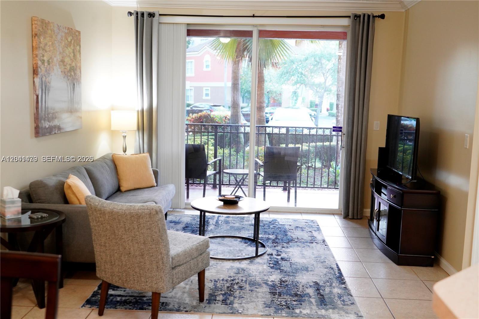 A living room features a gray sofa, an armchair, a coffee table, and a balcony — 4506 SW 160th Ave # 1116, Miramar FL 33027, MIRAMAR, FL
