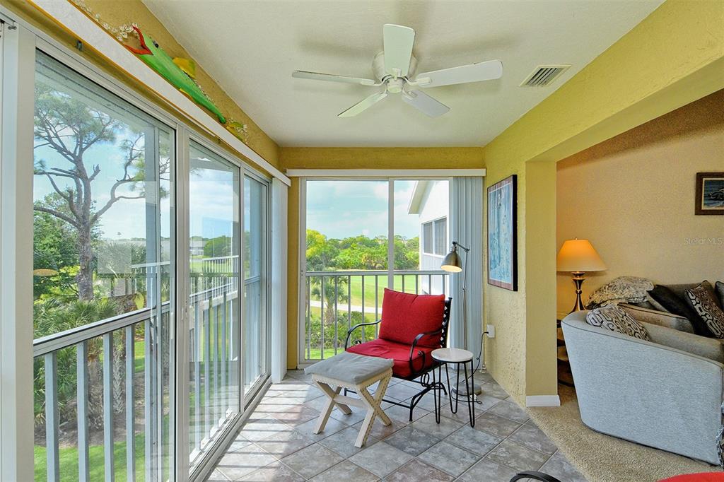 A sunroom with tile flooring, a ceiling fan, and sliding glass doors overlooking a golf course — 9610 CLUB SOUTH CIRCLE UNIT 4302, SARASOTA, FL
