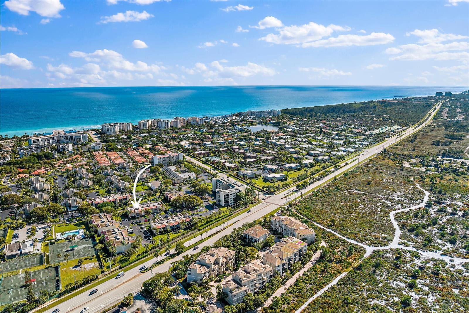 An aerial view shows a residential complex with tennis courts near a coastal highway — 1605 S Us Highway 1 # 106, Jupiter FL 33477, JUPITER, FL