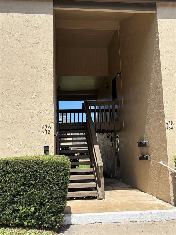 An exterior view shows a staircase leading to an upper-level walkway between apartment building units — 436 WINDMEADOWS STREET UNIT 436, ALTAMONTE SPRINGS, FL