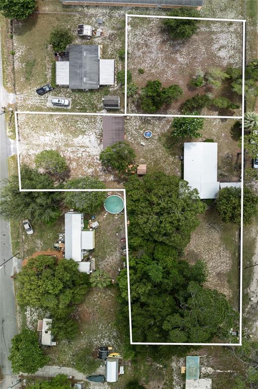 An aerial view shows several residential structures on a large, partially wooded lot — 27751 LUELLA AVENUE, PAISLEY, FL