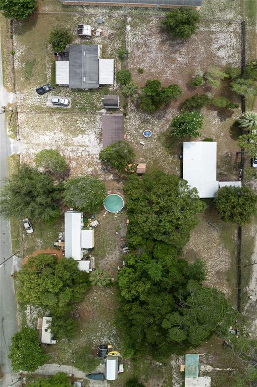 An aerial view shows multiple residential structures, trees, and swimming pools on a large lot — 27751 LUELLA AVENUE, PAISLEY, FL