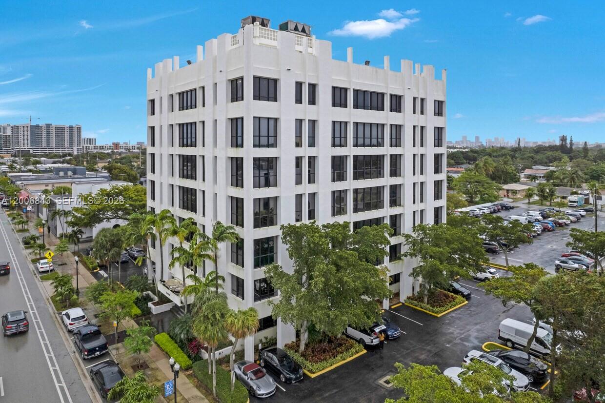An exterior view of a white multi-story office building with a parking lot and landscaping — 2450 Hollywood Blvd, Hollywood FL 33020, HOLLYWOOD, FL