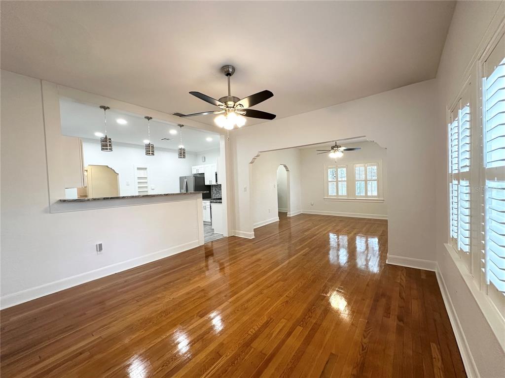 A dining room with hardwood floors, a ceiling fan, and an opening to the kitchen — 3025 W NORTH A STREET, TAMPA, FL