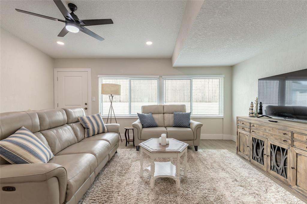 A living room features a leather sofa and loveseat, a coffee table, and a television console — 8 ROBBEN TERRACE, DAYTONA BEACH, FL