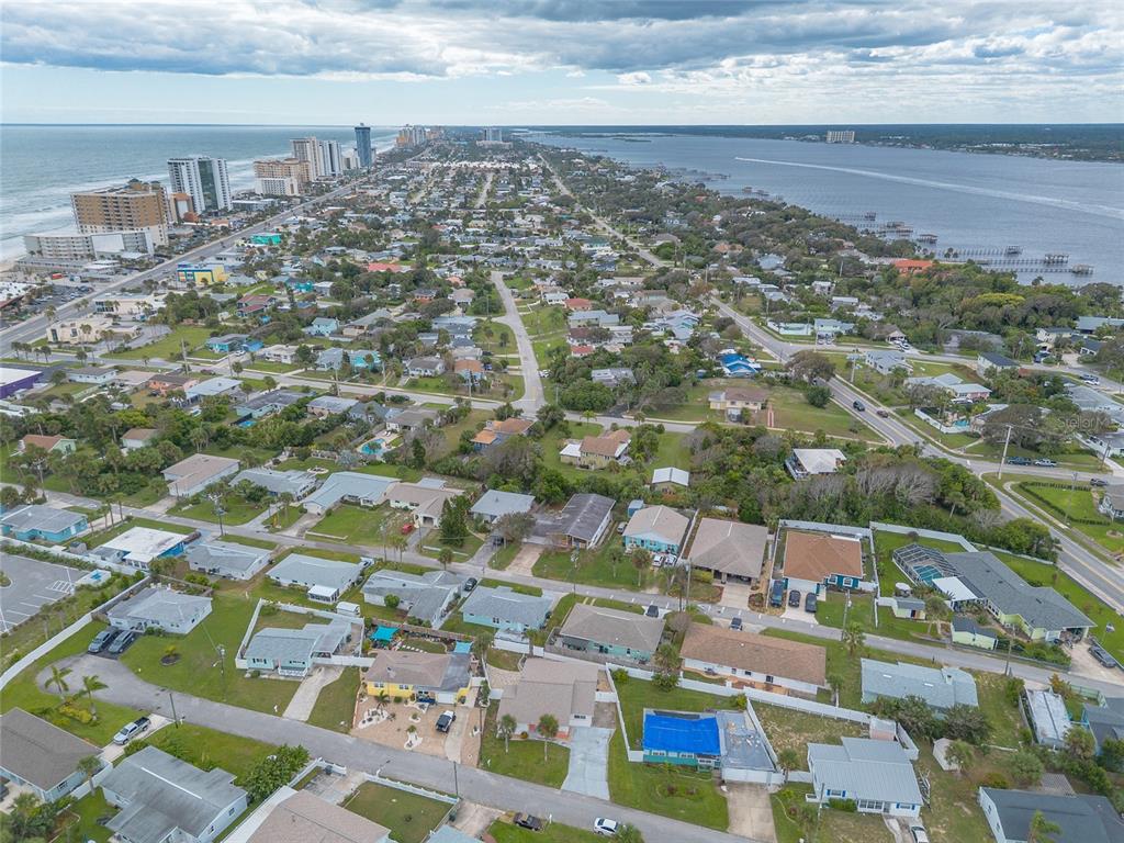 An aerial view shows a coastal residential neighborhood situated between the ocean and a bay — 8 ROBBEN TERRACE, DAYTONA BEACH, FL