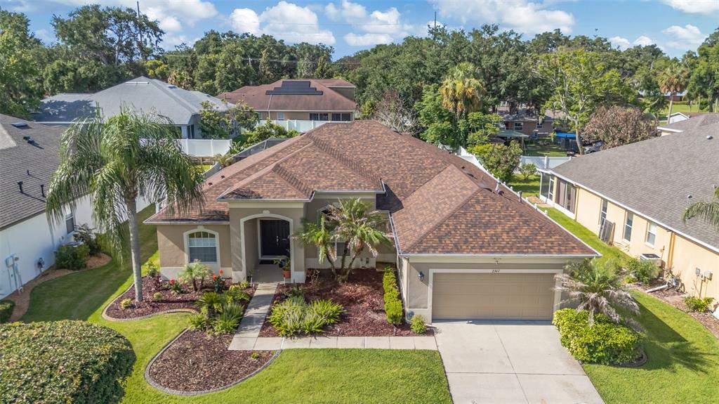An aerial view of a single-story suburban house with a brown shingled roof and driveway — 2307 SILVER TRUMPET COURT, VALRICO, FL