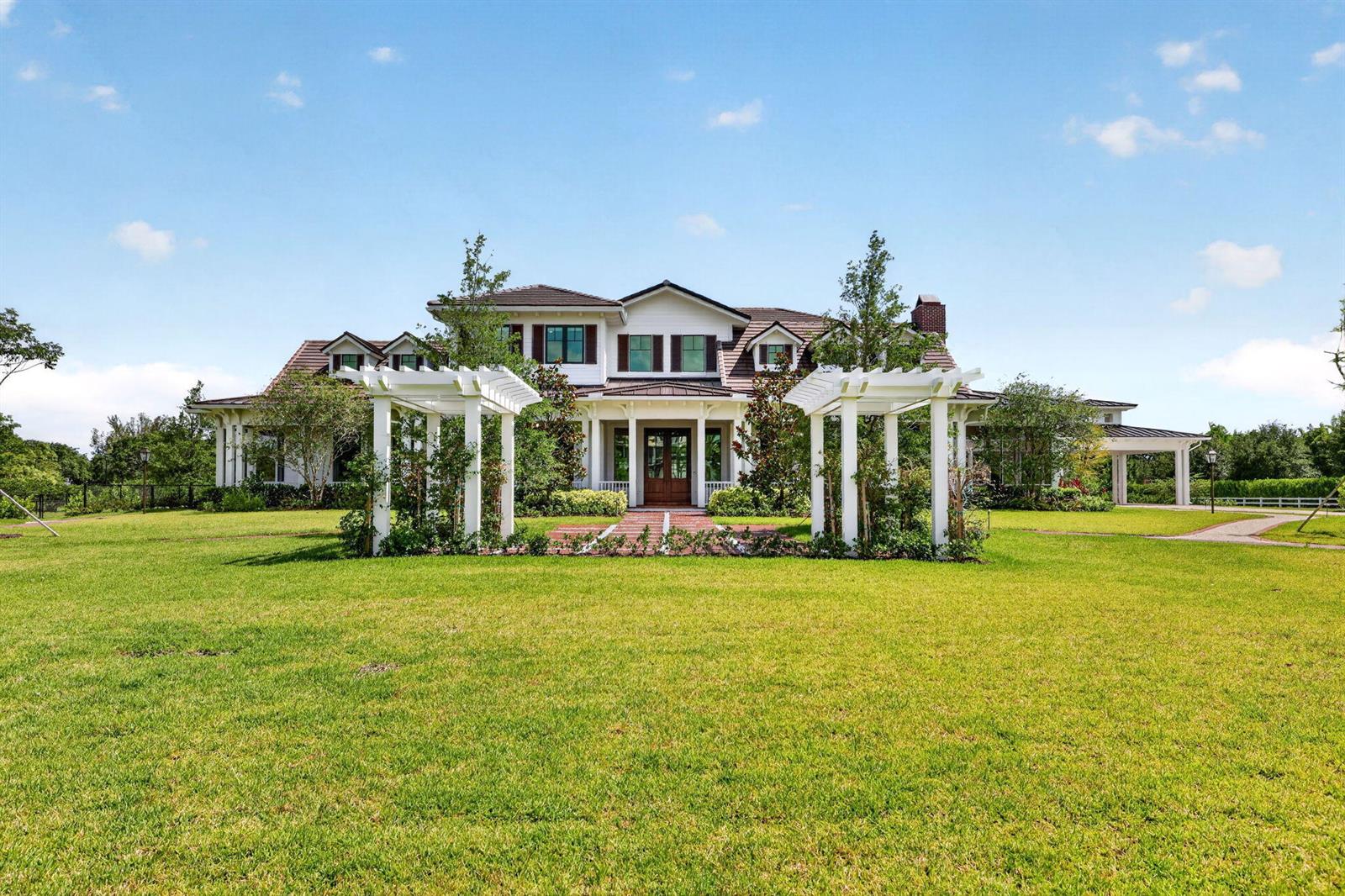 A large white house with a brown roof features two white pergolas over a walkway — 10250 El Paraiso Place, Delray Beach FL 33446, DELRAY BEACH, FL