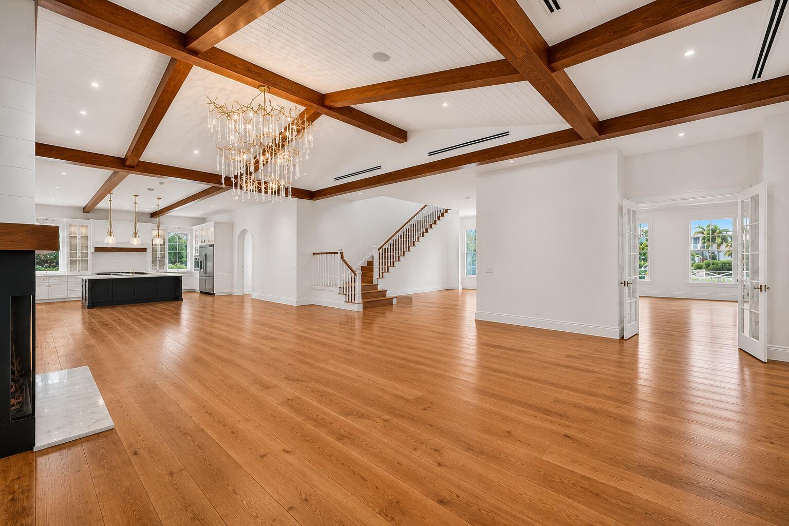 A spacious open-concept living area features wood-beamed ceilings, hardwood floors, and a modern kitchen — 10250 El Paraiso Place, Delray Beach FL 33446, DELRAY BEACH, FL