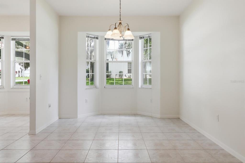 A dining area features tile flooring, white walls, a bay window, and a chandelier — 3540 S BELGRAVE DRIVE, INVERNESS, FL