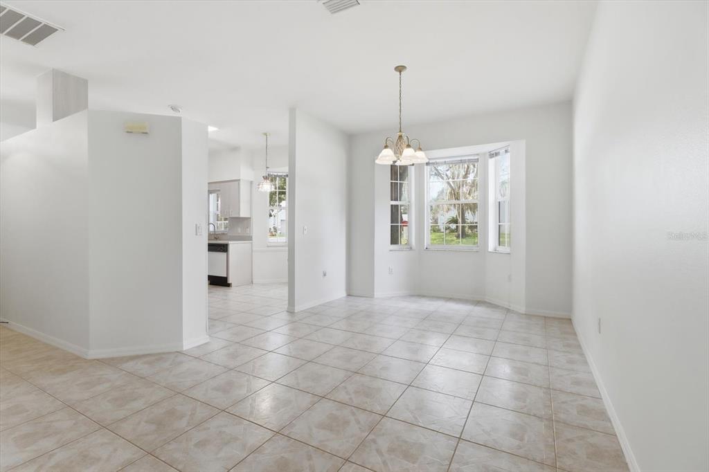 A bright dining area features tile flooring, a bay window, and a hanging chandelier — 3540 S BELGRAVE DRIVE, INVERNESS, FL