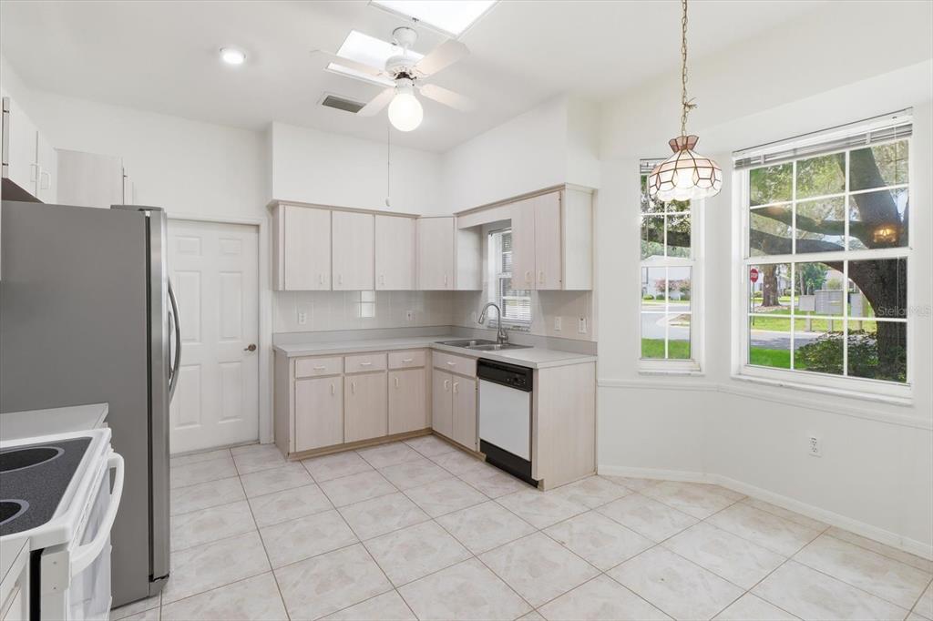 A kitchen features light wood cabinets, tile flooring, a ceiling fan, and a breakfast nook — 3540 S BELGRAVE DRIVE, INVERNESS, FL
